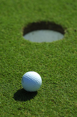 Golf ball close to the hole on a golf green