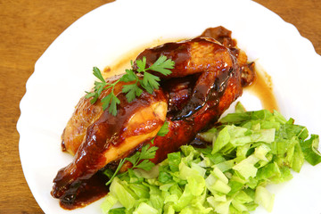 Roast chicken on a white plate with brown sauce