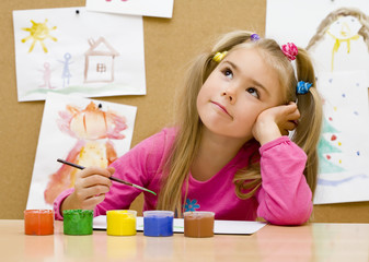 Little girl paints pictures in bright colours