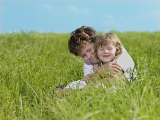 two children on green grass smiling