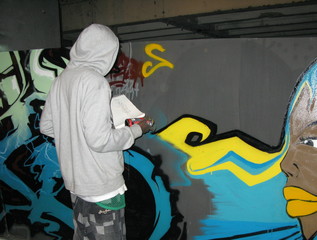 Graffiteur devant un mur.