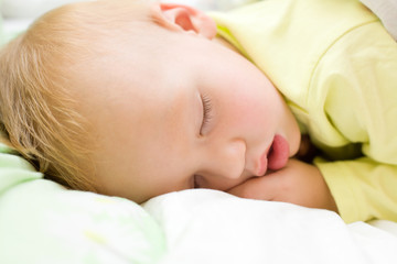 Restful two years baby boy sleeping on bed
