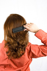 Fototapeta premium Woman brushing her hair isolated on white