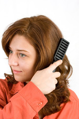 Fototapeta premium Woman brushing her hair isolated on white