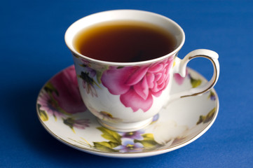 cup of black tea on a blue background