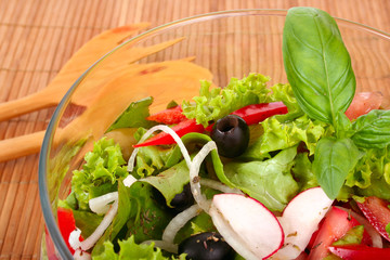 Fresh salad with onion, tomato and basil on black