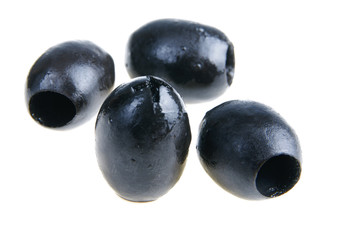 Four black olive isolated on white background close-up.