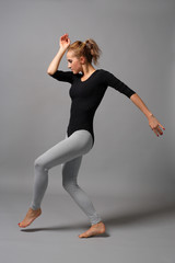 young beautiful ballerina posing on grey background