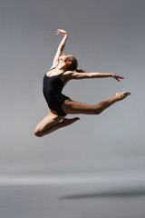 Fototapeta na wymiar Młoda piękna balerina posing na szarym tle