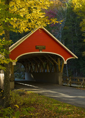 Colorful red covered bridge in New Hampshire .