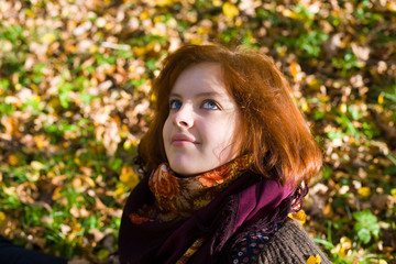 Portrait of the girl with blue eyes against autumn foliage