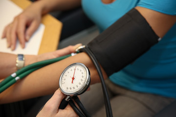 Arzt mit Stehtoskop misst Patient den Blutdruck