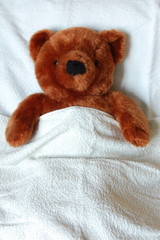 sick teddy bear with injury in a bed in the hospital
