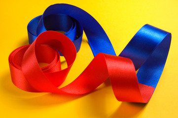 satin ribbon.Two color satiny tapes on a yellow background