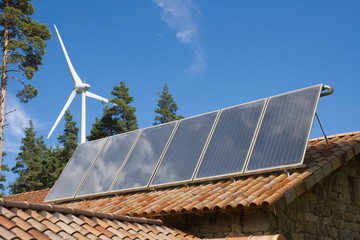 Energies renouvelables : panneaux solaires sur un toit et éolienne