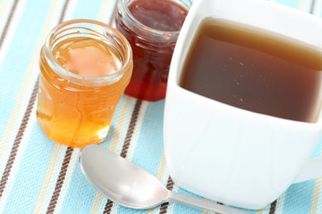 cup of delicious tea with sweet confiture