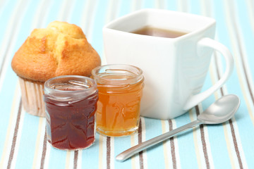 cup of delicious tea with sweet muffin and confiture