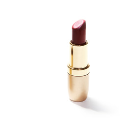 Open tube of red lipstick on white background