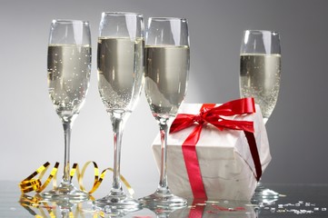 Glasses of champagne, gifts with red tapes and bows
