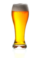 Glass of beer close-up with froth over white background