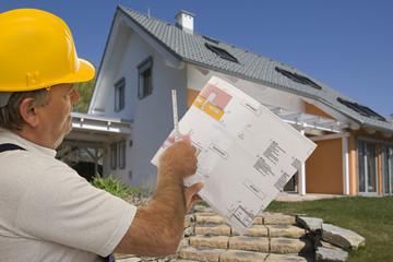 Bauarbeiter mit Plan eines Architekten