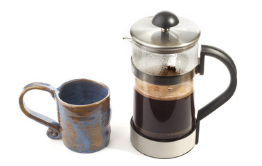 a blue mug and a pot of coffee