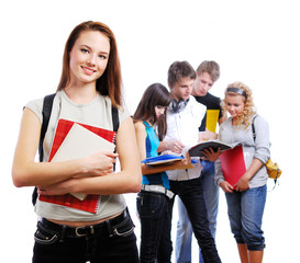 Graceful female student with books in hands looking at camera.