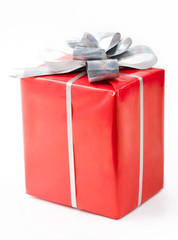 Isolated gift in red decorative box bound with silver ribbon