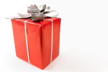 Corner of red giftbox decorated with silver shiny ribbon