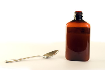 A metal spoon and some cough medicine