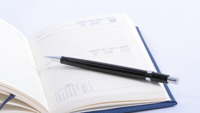 an open notebook with pencil