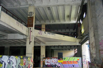 Intérieur d'usine en béton avec graffitis.