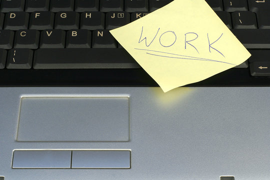 Post-it memo with word work on laptop keyboard