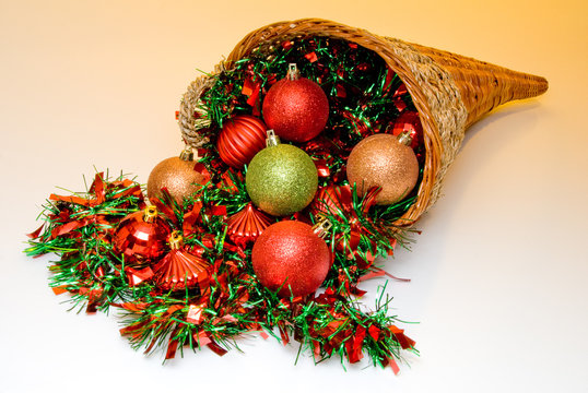 A cornucopia filled with holiday Christmas ornaments.