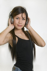 Naklejka premium Sexy young girl listening to music on headphones