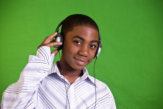An African American boy listening to music through headphones.