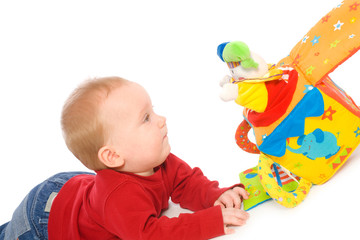 Happy baby boy (6 months old) playing with soft toys, smiling.