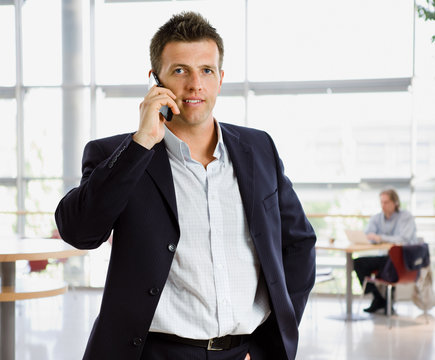 Happy businessman calling on mobile phone.