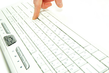 male hands typing on a white computer keyboard