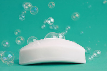 white soap bar with bubles, turquoise background