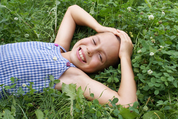 Smiling preteen girl lying on clover