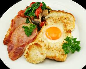 Egg embedded in toast with bacon, mushrooms and spinach