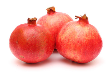 Three fresh appetizing pomegranates on white background