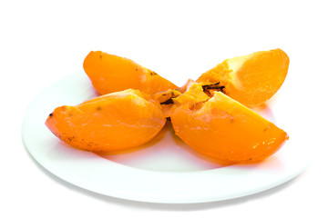 Persimmon on white plate. Isolated.