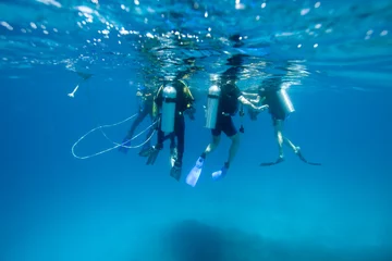 Fotobehang Divers at the surface, waiting to climb into the boat © DJ
