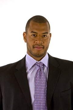 A black man in a nice business suit and purple shirt and tie