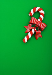 Candy cane with red ribbon on green background, Christmas