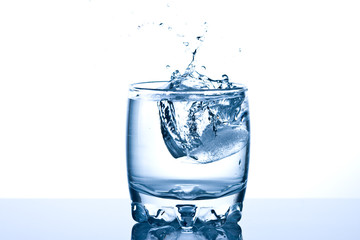 Ice  splashing in a cool glass of water