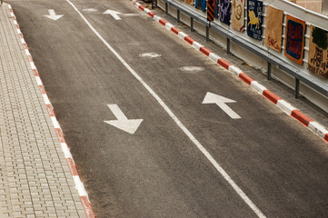 Close-up of a road with white line and arrows