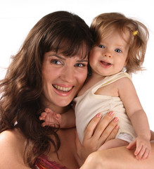 A happy mother holds a baby on hands.